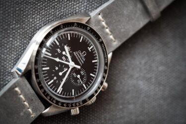 Close up of omega speedmaster moonwatch on grey material background